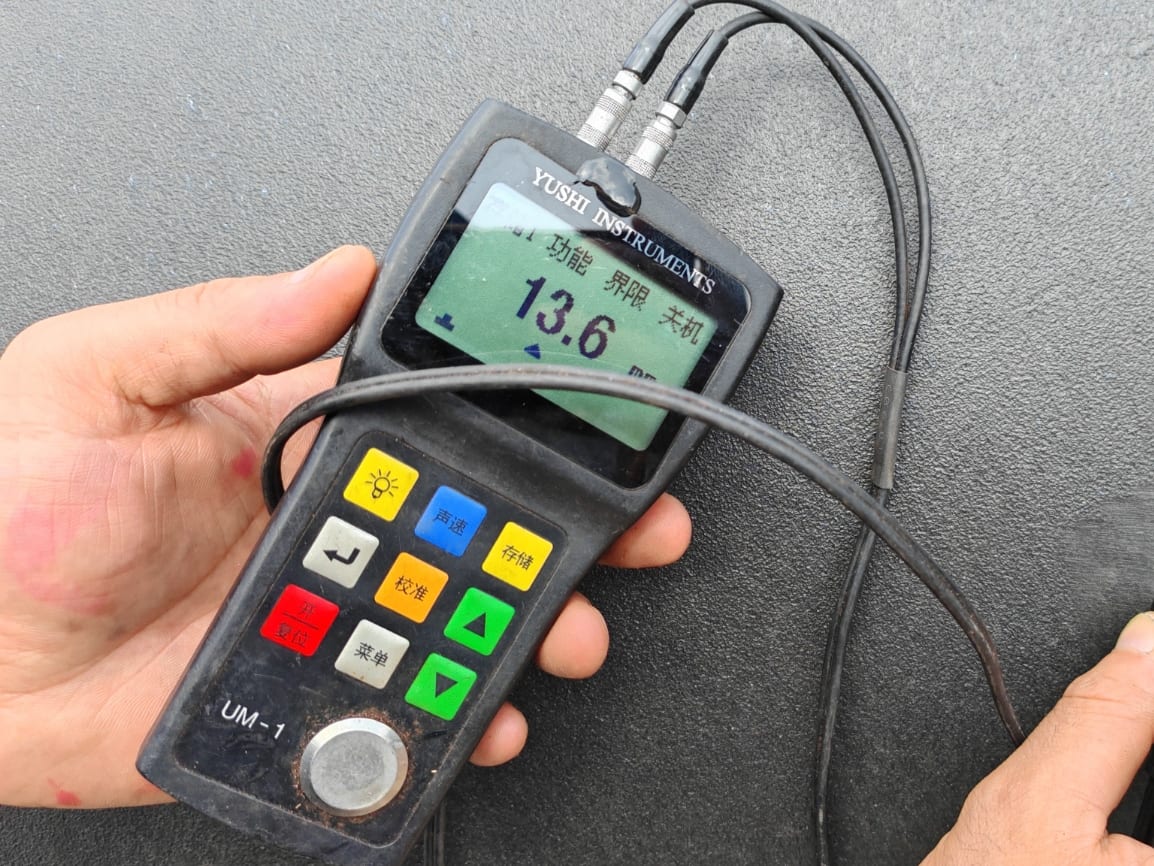 Ultrasonic thickness gauge reading the thickness of a steel plate